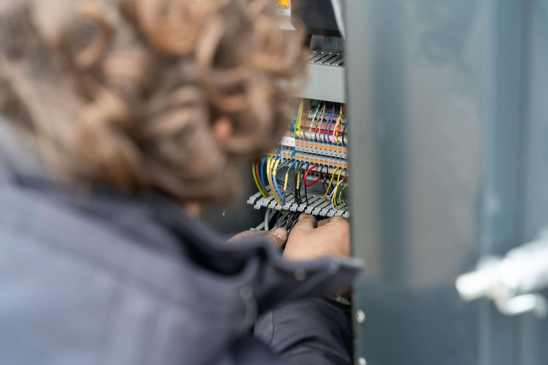 Industrial sliding gate with technician at an access control pillar